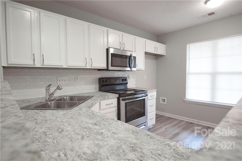 3235 Blythe Ridge Court Charlotte, NC 28213 - Photo 1 of 14 a kitchen with granite countertop a sink stove and microwave