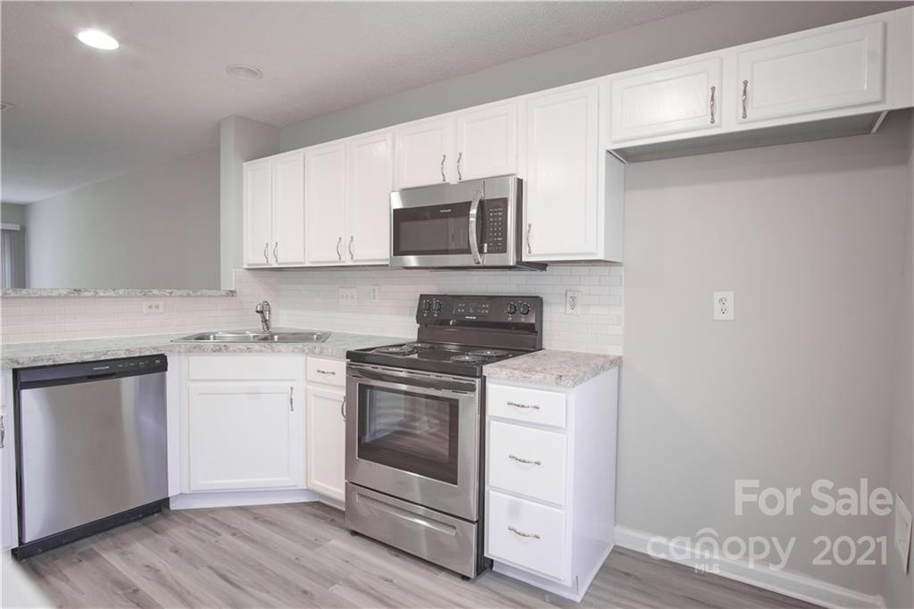 3235 Blythe Ridge Court Charlotte, NC 28213 - Photo 2 of 14 a kitchen with stainless steel appliances granite countertop a stove and white cabinets