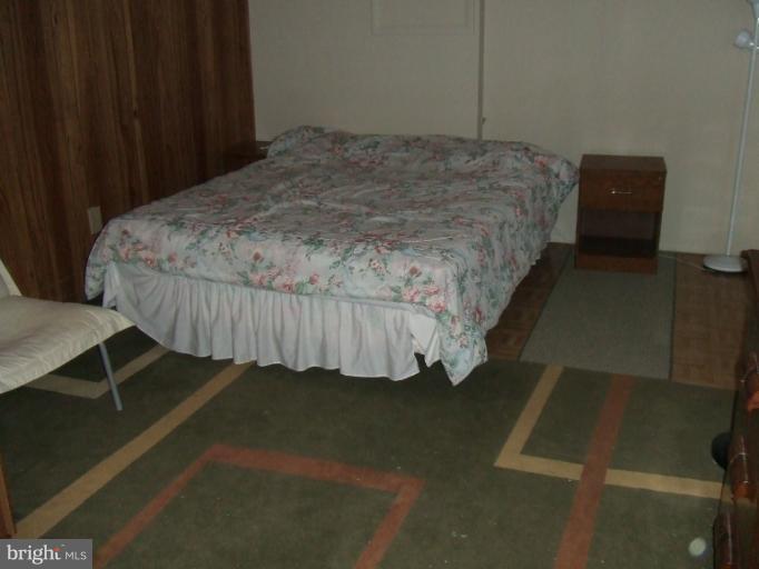 23 Cross Ridge Court Germantown, MD 20874 - Photo 16 of 19 a bed sitting in a bedroom next to a wooden cabinet