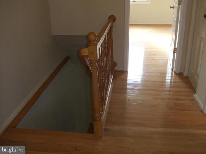 23 Cross Ridge Court Germantown, MD 20874 - Photo 9 of 19 a view of a hallway with wooden floor and stairs