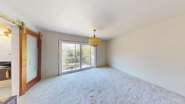 a view of a hallway with wooden floor and windows