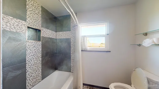 a hallway with painting on the wall and a potted plant