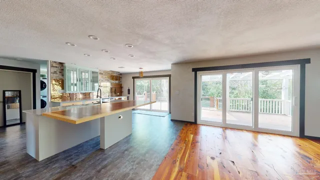 a large kitchen with stainless steel appliances a large window a sink and cabinets