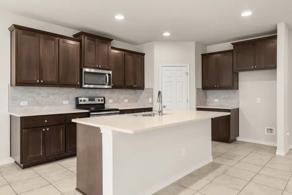 a kitchen with stainless steel appliances a refrigerator sink stove microwave and cabinets