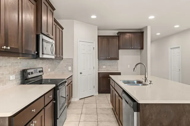 a kitchen with granite countertop cabinets stainless steel appliances and a counter space
