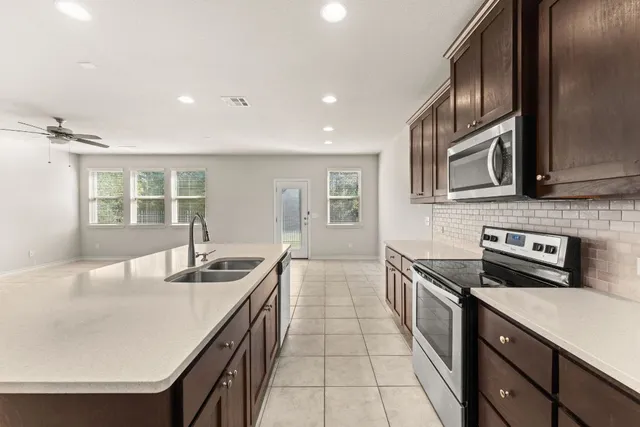 a kitchen that has a sink a stove and a table in it