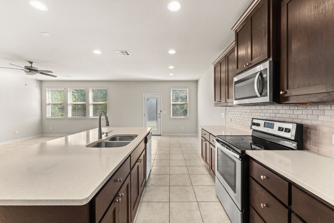 740 Aliso Trail Leander, TX 78641 - Photo 12 of 35 a kitchen with granite countertop cabinets stainless steel appliances and a counter space