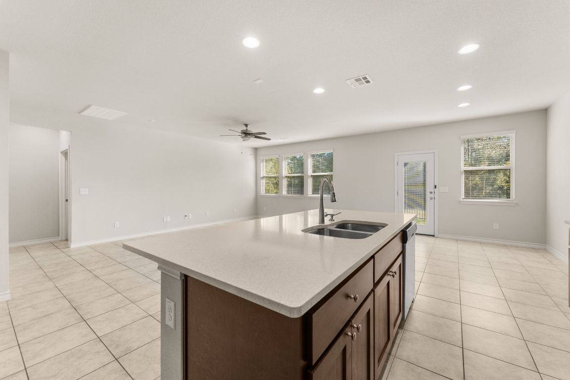 740 Aliso Trail Leander, TX 78641 - Photo 13 of 35 a kitchen that has a sink a stove and a table in it
