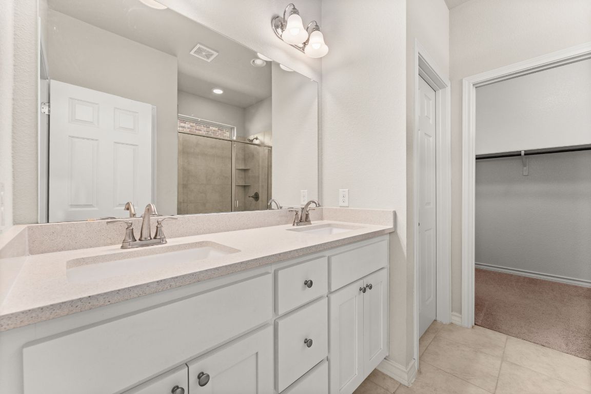 740 Aliso Trail Leander, TX 78641 - Photo 17 of 35 a bathroom with double sink and a mirror