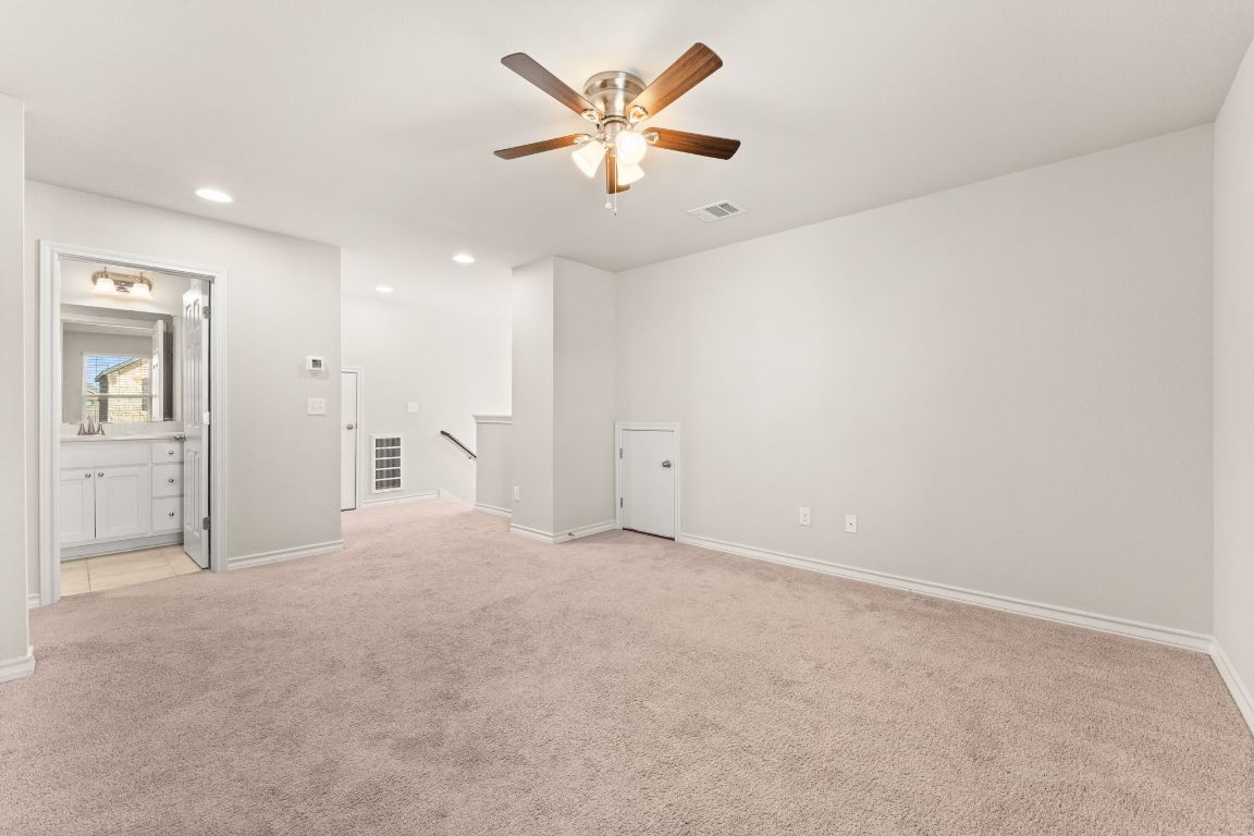 740 Aliso Trail Leander, TX 78641 - Photo 22 of 35 an empty room with chandelier fan and windows