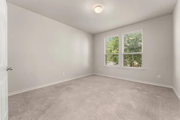 an empty room with windows and closet