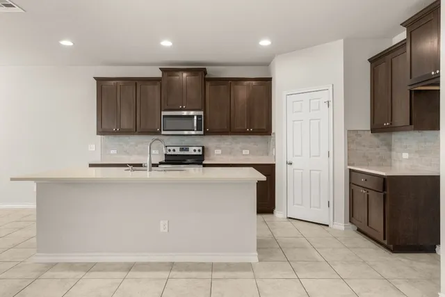 a kitchen with stainless steel appliances a refrigerator sink stove microwave and cabinets