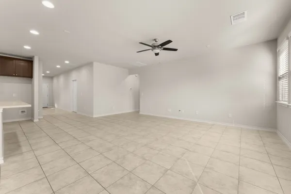 an empty room with kitchen view and a window
