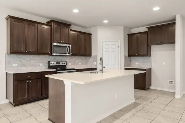 a kitchen with stainless steel appliances granite countertop a sink a stove and a refrigerator