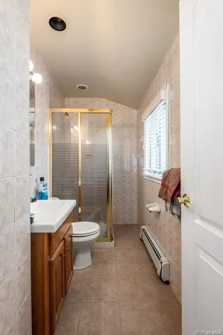 a bathroom with a granite countertop sink a toilet a mirror and shower