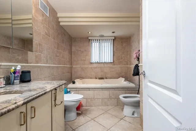 a bathroom with a granite countertop toilet a sink and a bathtub