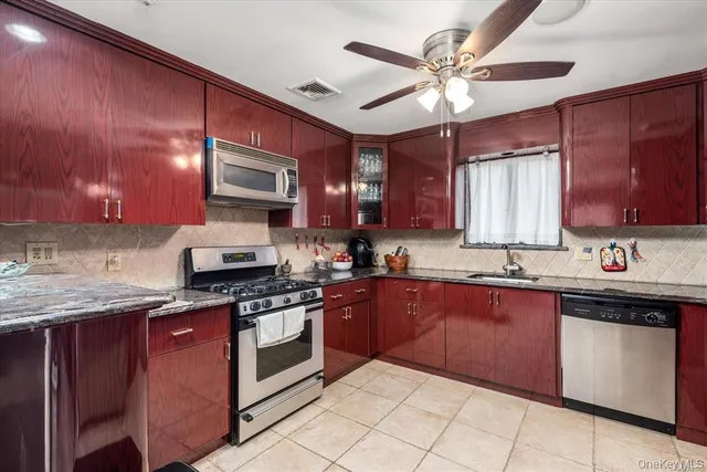 a kitchen with stainless steel appliances granite countertop wooden cabinets stove top oven and sink