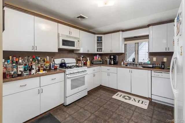 a kitchen with stainless steel appliances granite countertop a sink a stove and cabinets