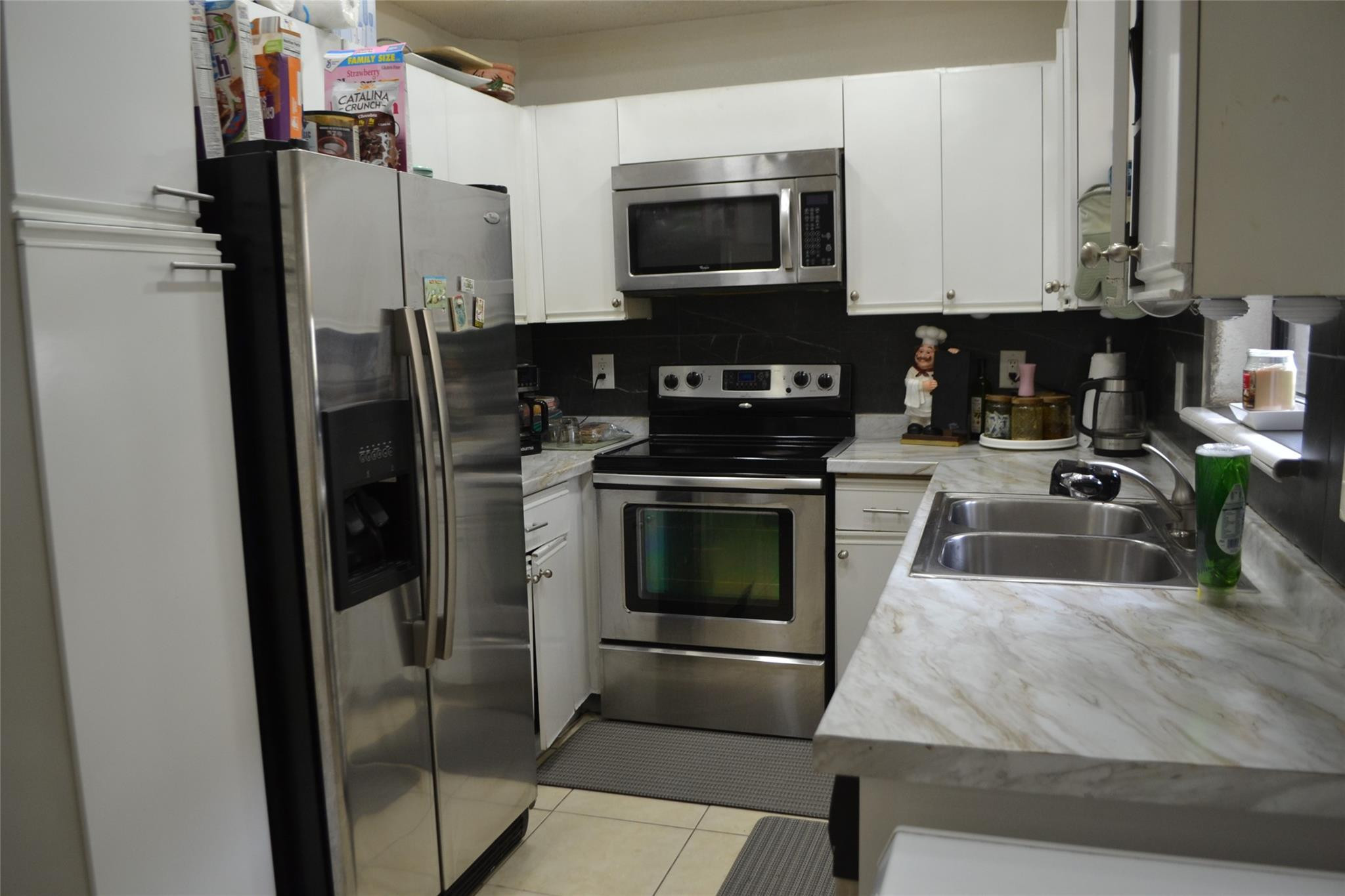 3539 Inverrary Boulevard West Lauderhill, FL 33319 - Photo 5 of 33 a kitchen with stainless steel appliances a stove a microwave and a refrigerator