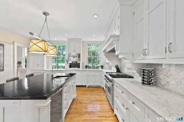 a kitchen with granite countertop a sink stove and cabinets