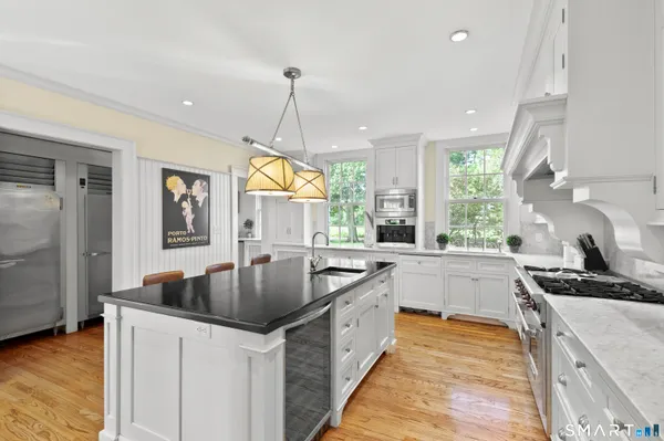 a large kitchen with a lot of counter space and wooden floor