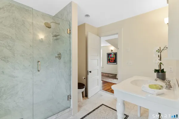 a bathroom with a sink toilet a mirror and shower