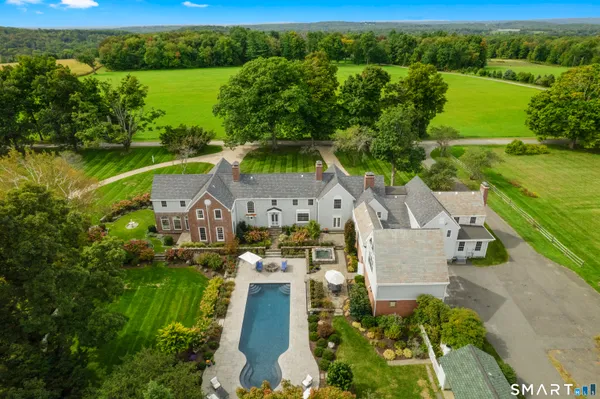 an aerial view of a house with a garden and lake view