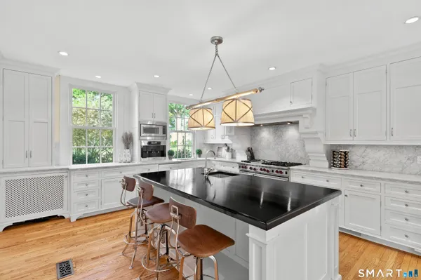 a kitchen with kitchen island granite countertop a sink a counter space appliances and cabinets