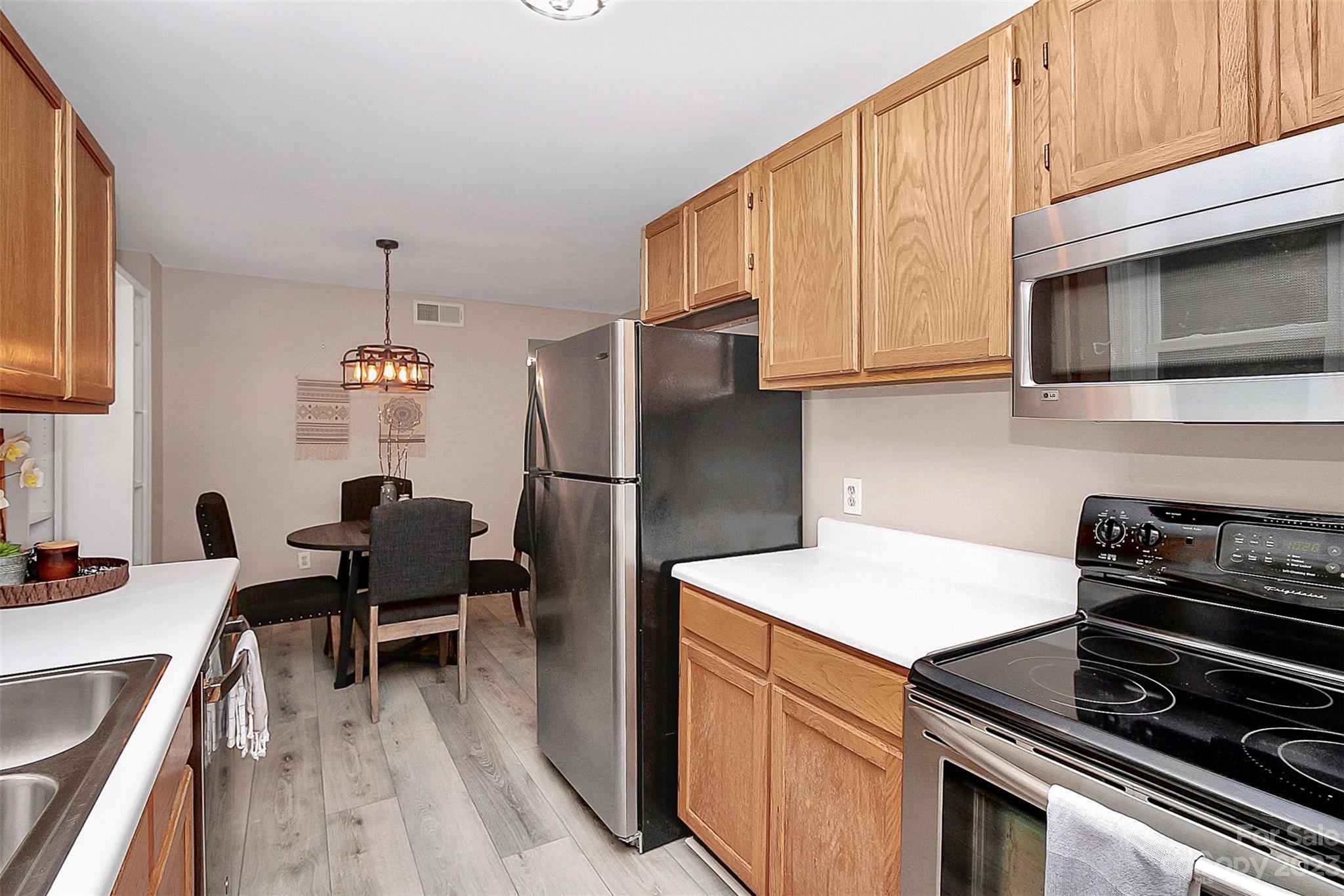 430 Queens Road, Unit 212 Charlotte, NC 28207 - Photo 17 of 23 a kitchen with a sink a microwave a stove and refrigerator