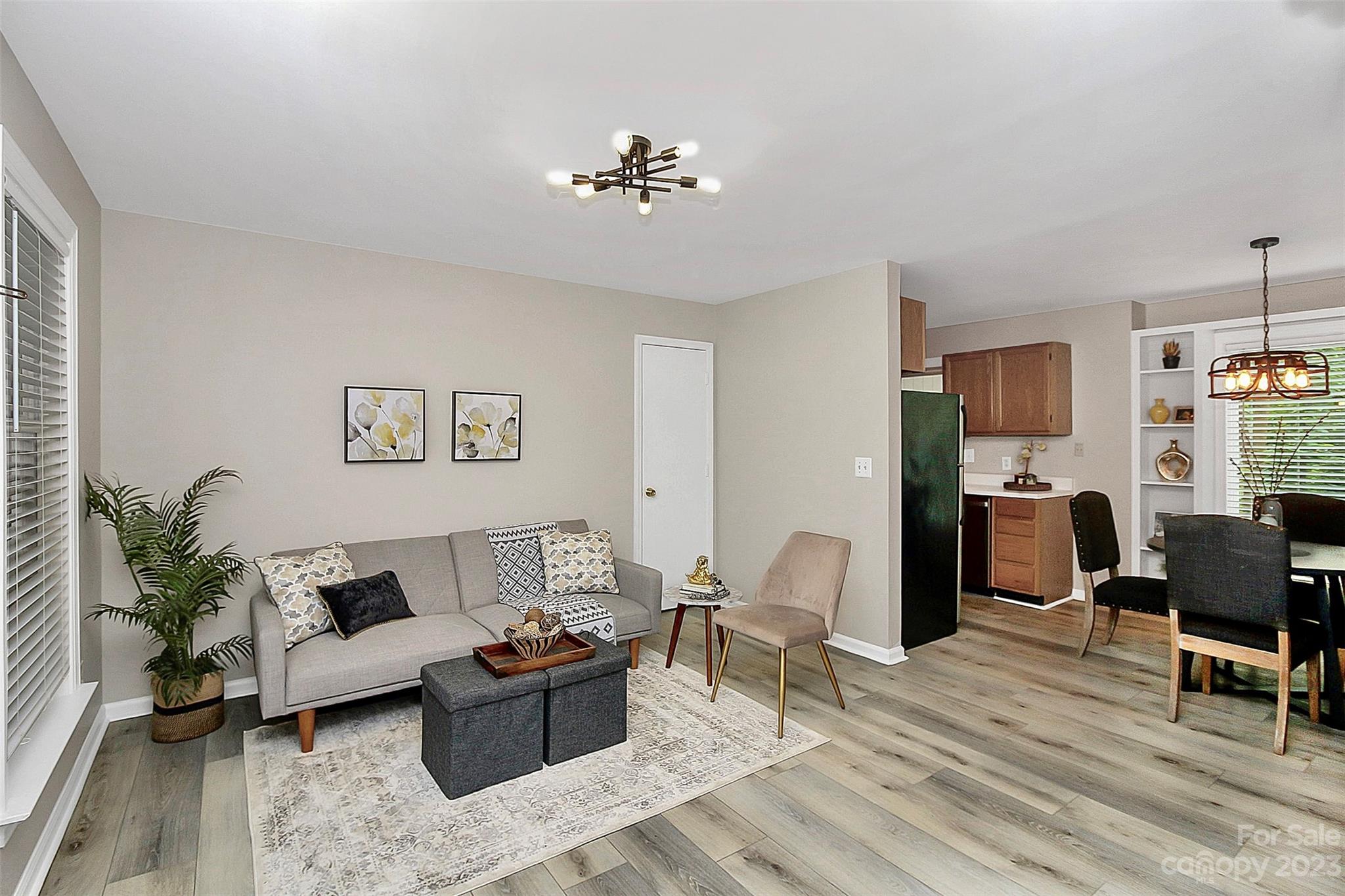 430 Queens Road, Unit 212 Charlotte, NC 28207 - Photo 4 of 23 a living room with furniture or couch and a dining table with wooden floor
