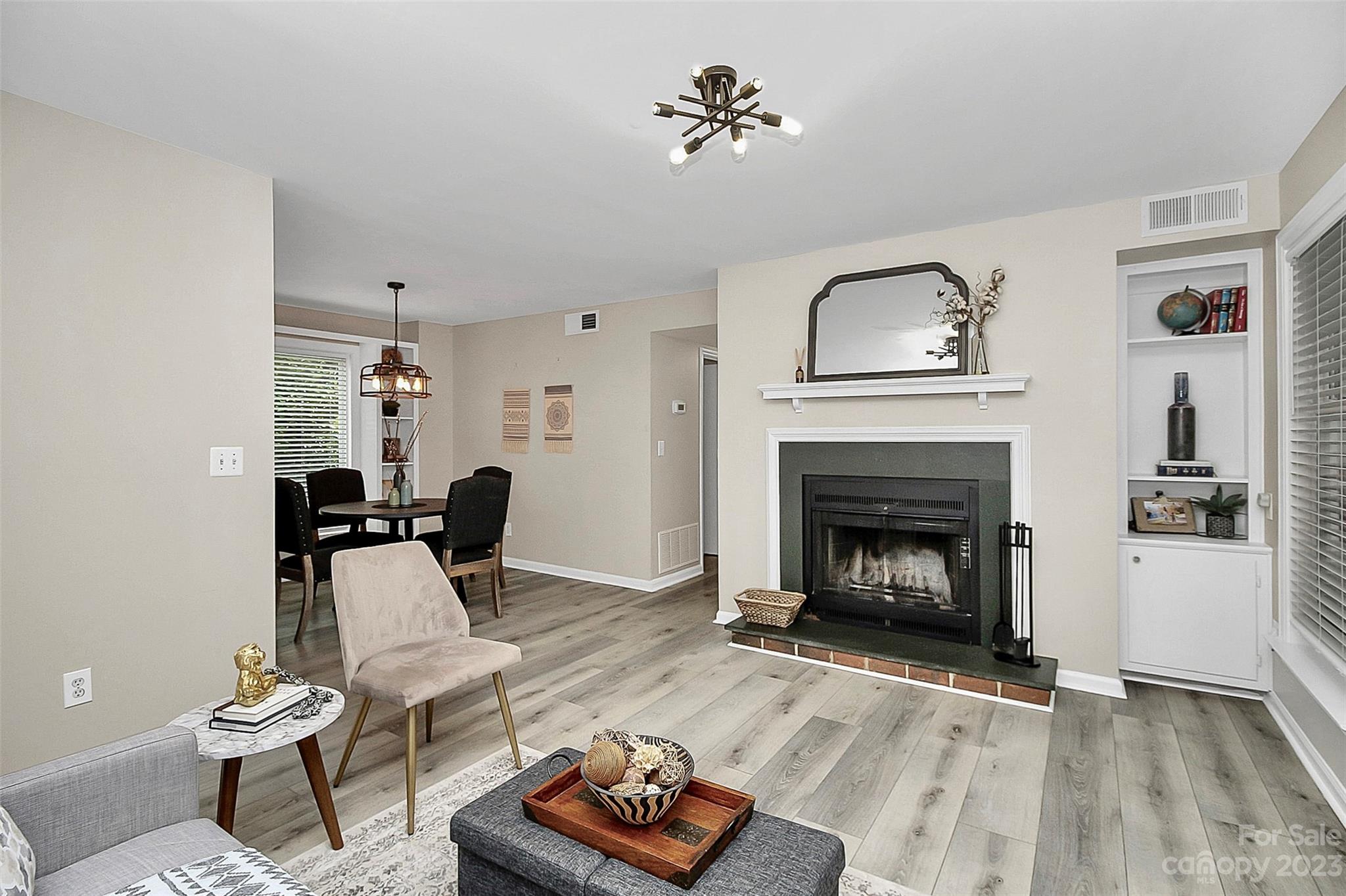 430 Queens Road, Unit 212 Charlotte, NC 28207 - Photo 6 of 23 a living room with furniture a fireplace and wooden floor