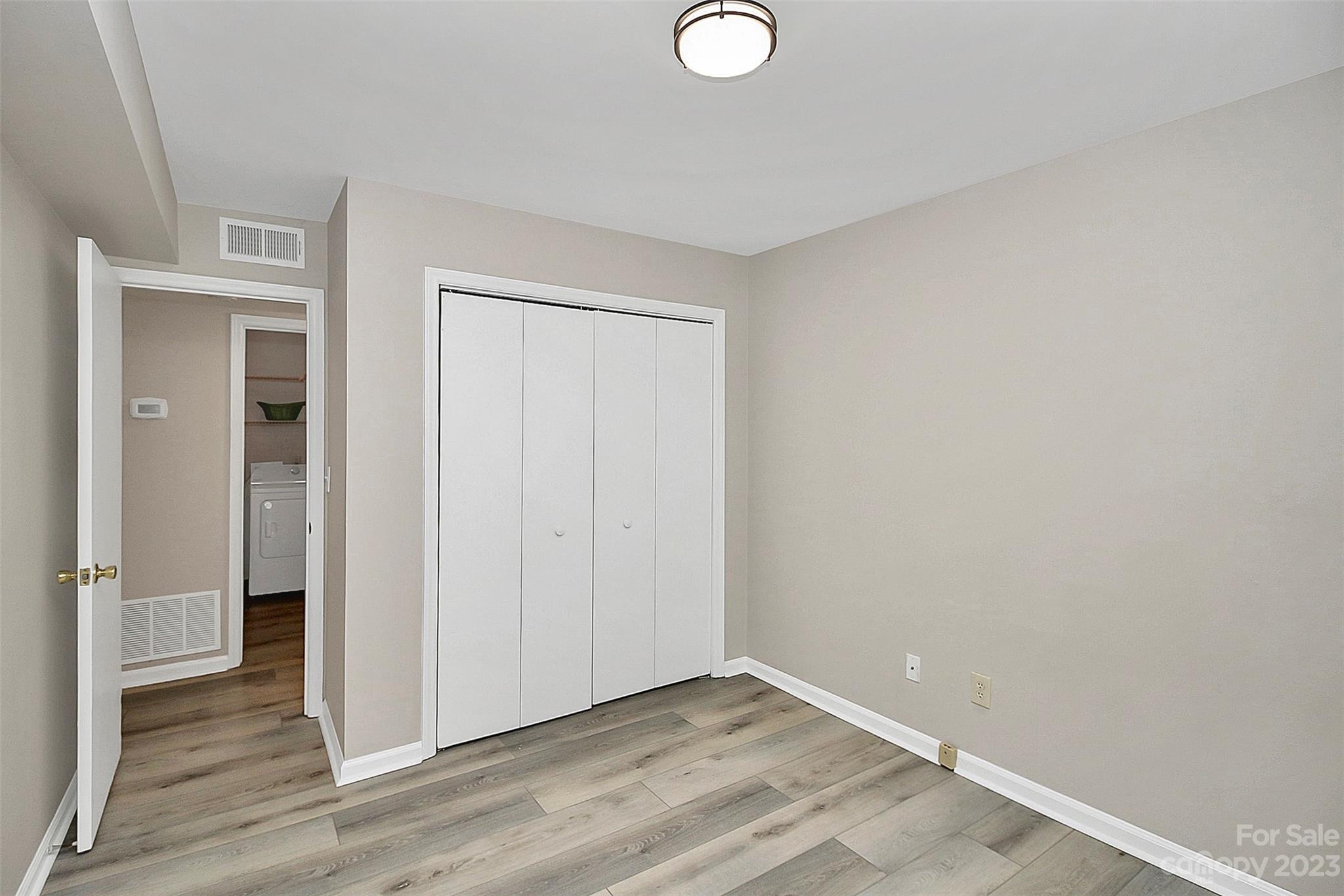 430 Queens Road, Unit 212 Charlotte, NC 28207 - Photo 8 of 23 a view of an empty room with wooden floor