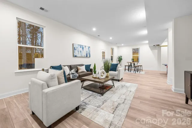 a living room with furniture wooden floor and a large window