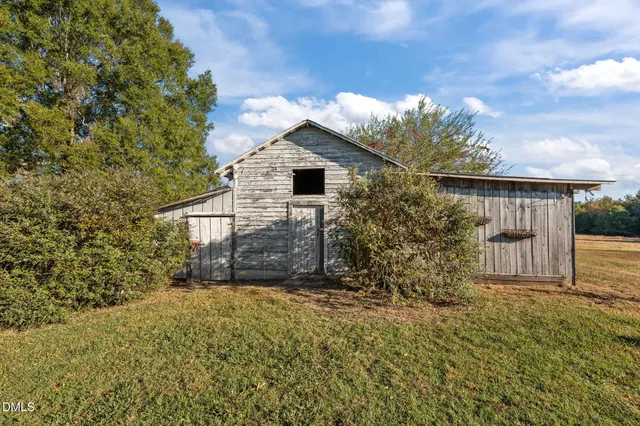 a view of a house with a small yard plants and large tree