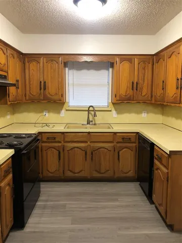 a kitchen with stainless steel appliances granite countertop a sink a stove cabinets and wooden floor