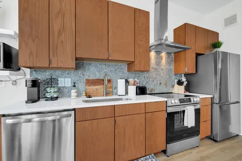 a kitchen with stainless steel appliances granite countertop a refrigerator sink and cabinets