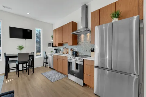 a kitchen with stainless steel appliances a refrigerator stove microwave and white cabinets