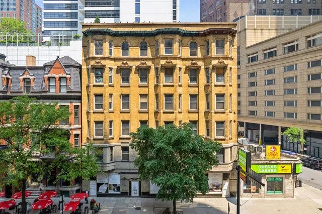 a view of a building with a lot of windows and a yard