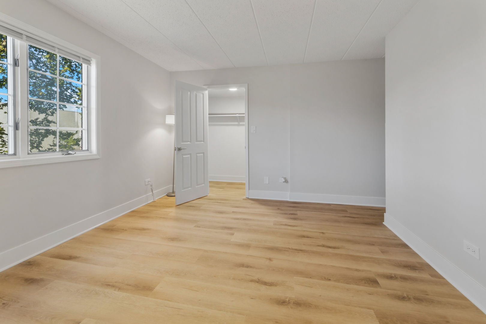 18310 Robin Lane, Unit D2 Homewood, IL 60430 - Photo 13 of 17 a view of an empty room with wooden floor and a window