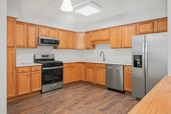 a kitchen with granite countertop a refrigerator stove top oven and sink