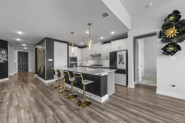 a kitchen with kitchen island stainless steel appliances a sink and refrigerator