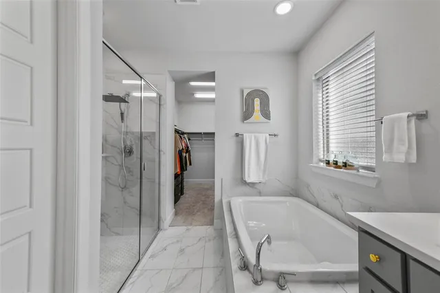 a bathroom with a tub a shower and a sink