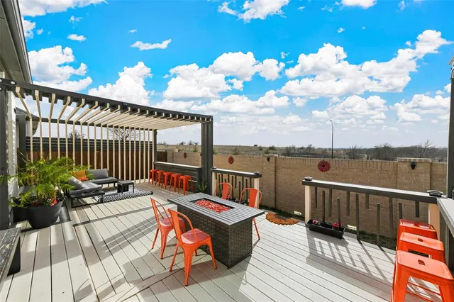 a balcony with wooden floor table and chairs