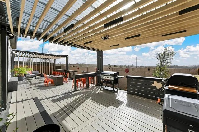 a roof deck with a table and chairs and potted plants