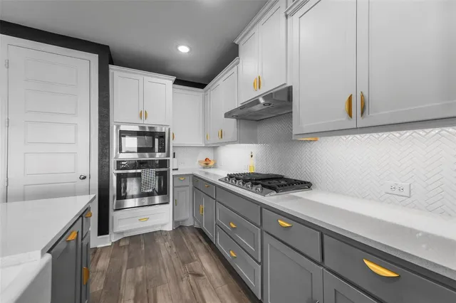 a kitchen with stainless steel appliances a sink stove and cabinets