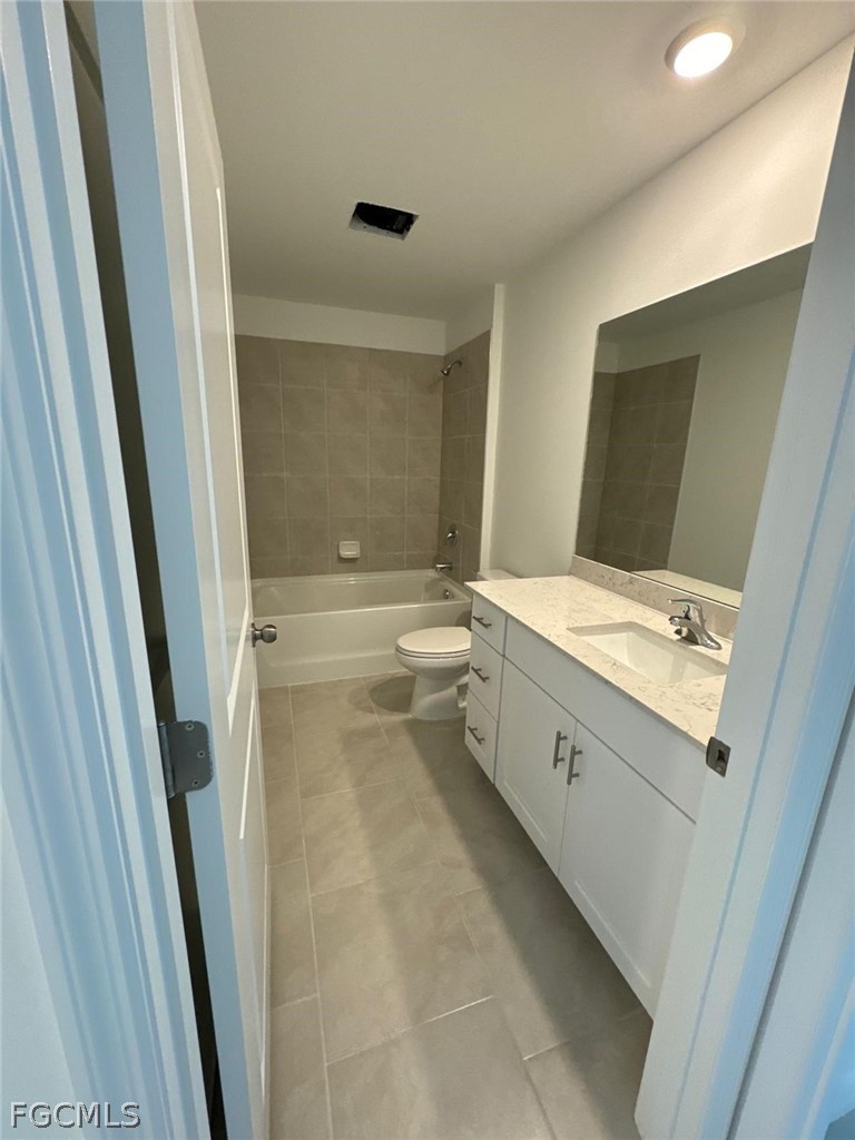 12312 Amber Waves Road Lehigh Acres, FL 33974 - Photo 23 of 33 a bathroom with a double vanity sink toilet and tub