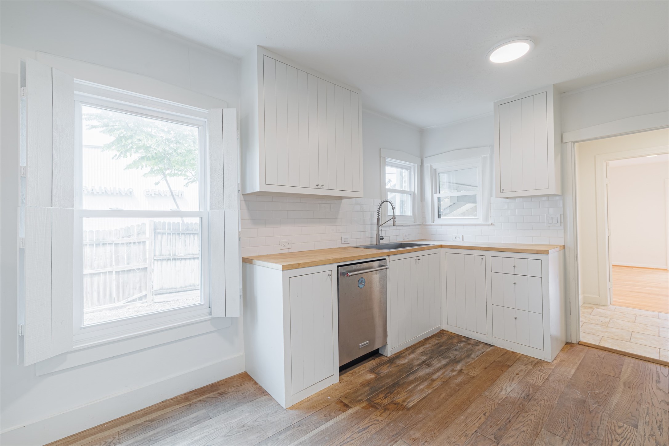 2438 Albans Road Houston, TX 77005 - Photo 14 of 34 a kitchen with granite countertop white cabinets and white appliances with wooden floor
