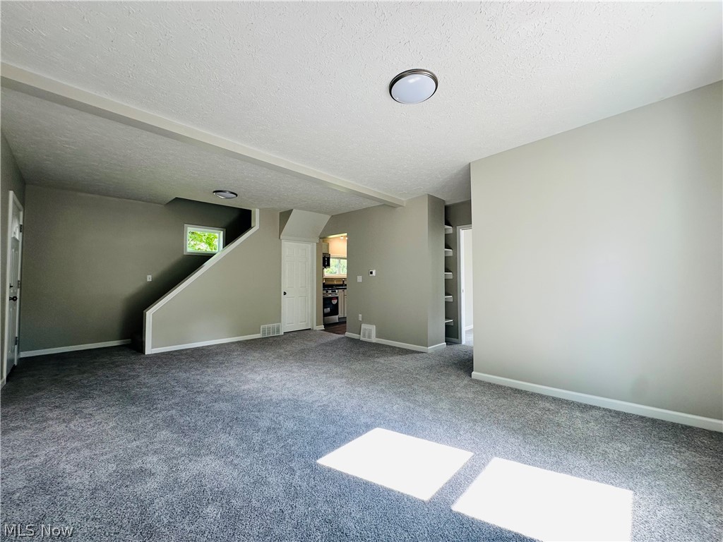 1003 Ravenna Road Kent, OH 44240 - Photo 3 of 16 Unfurnished living room featuring a textured ceiling and carpet flooring