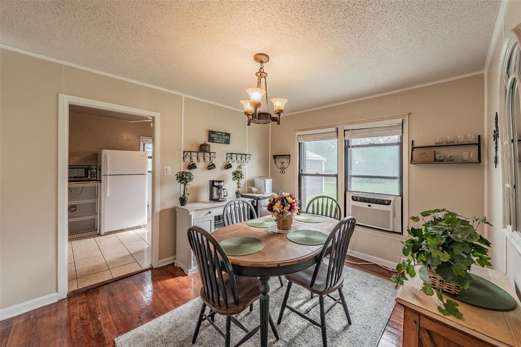 1802 Keneipp Road Carrollton, TX 75006 - Photo 6 of 22 Dining area featuring hardwood floors, a chandelier, and a window with a view of the outdoors