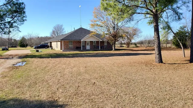 a front view of a house with a yard and trees